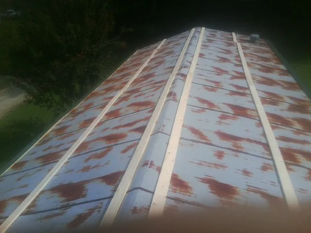 Rusted metal roof panels with new wood purlins before replacement — Storm Damage Roof Repair in Bohannon by Roofing Brothers