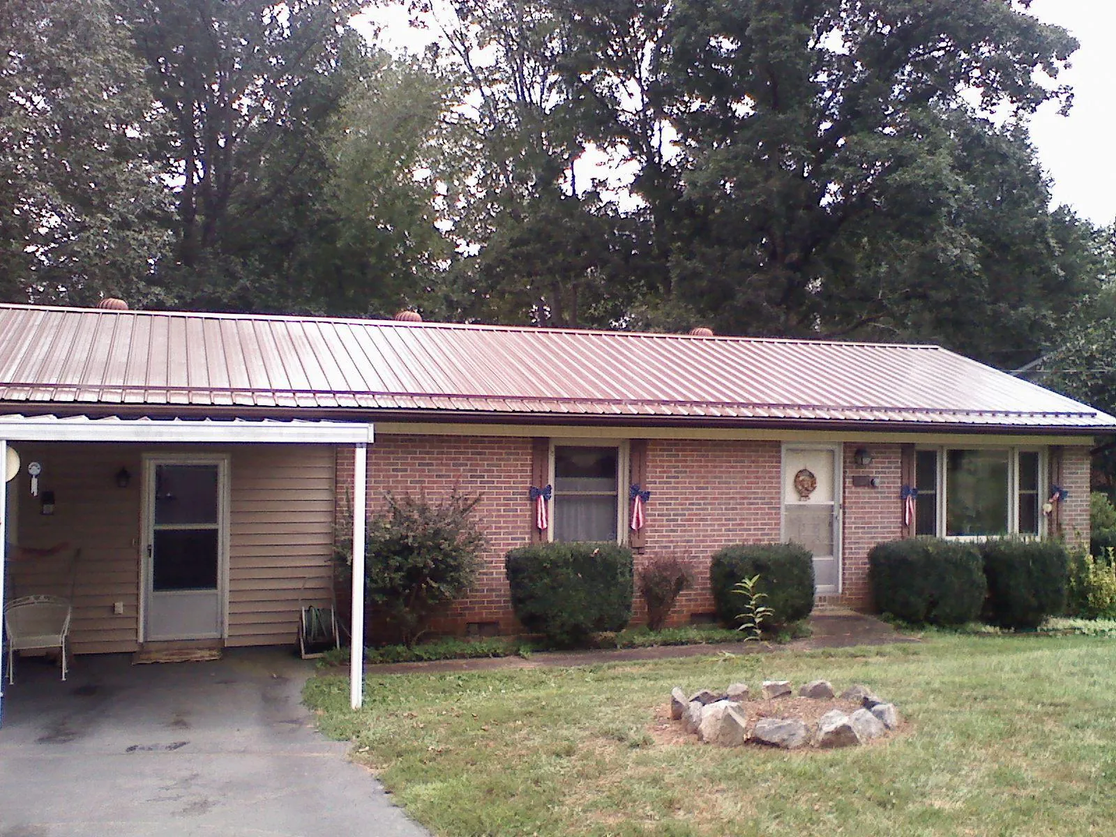 Bronze metal roof and carport on a brick ranch home — Roof Repair work by our crew in Bohannon