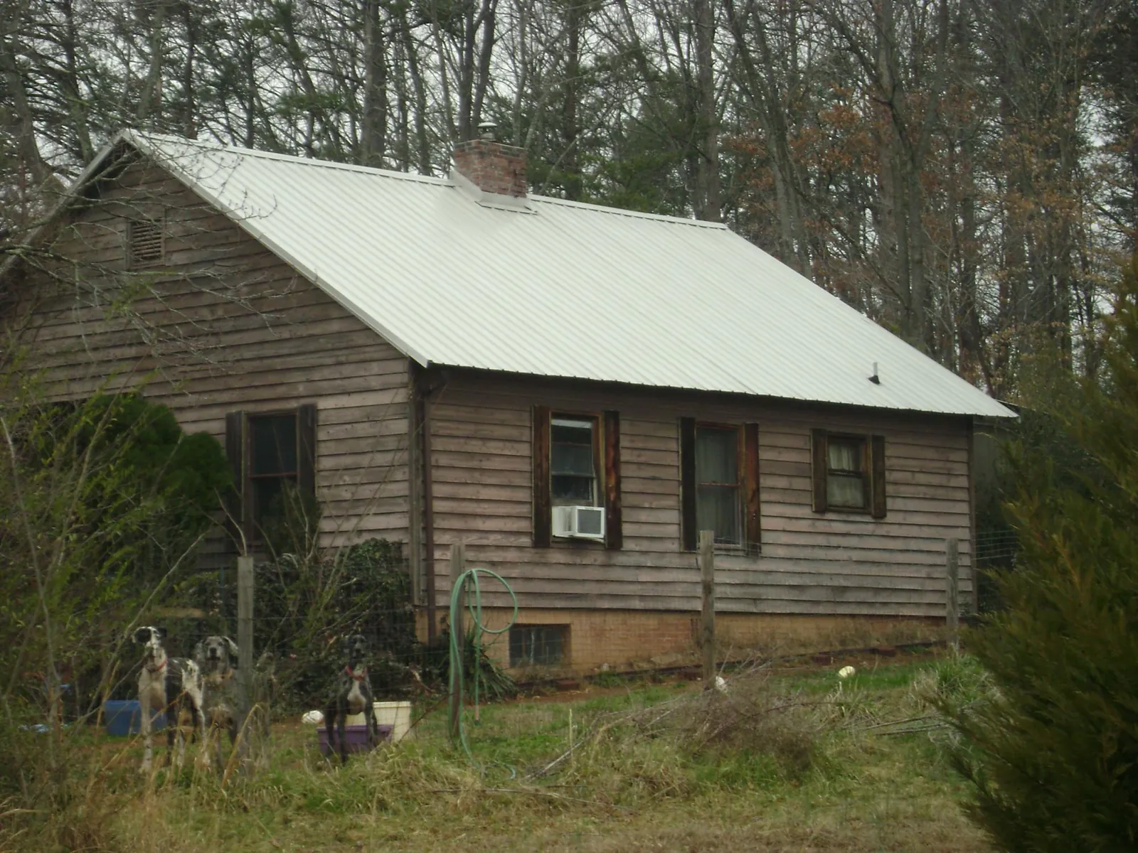 White metal roof on an old wood sided farmhouse, from a Metal Roof Installation job in Bohannon